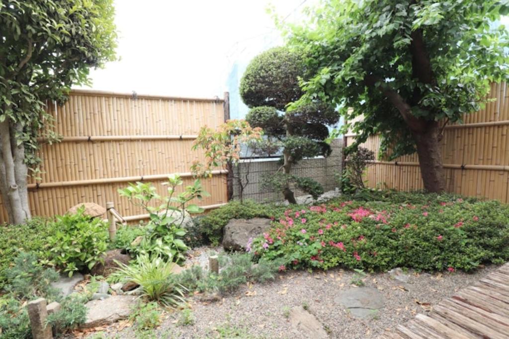 a garden with a fence and some flowers at Saitama Niiza House in Niizo