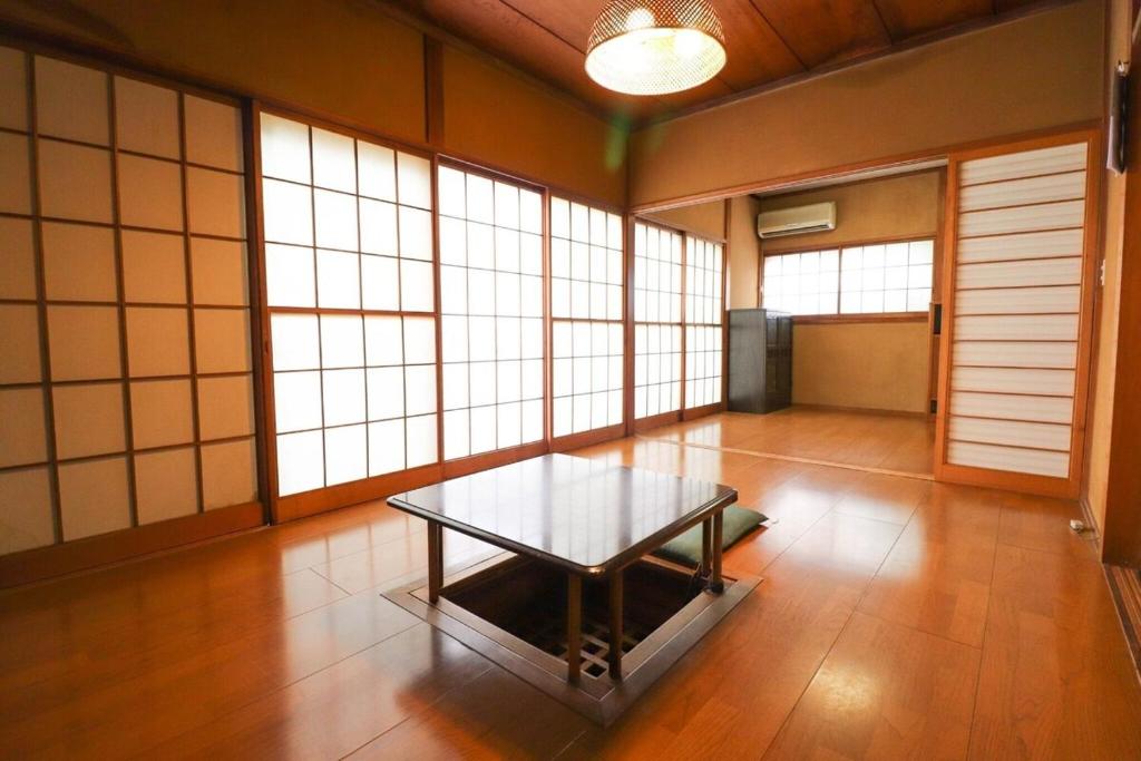 a room with a table in a room with windows at Saitama Niiza House in Niizo