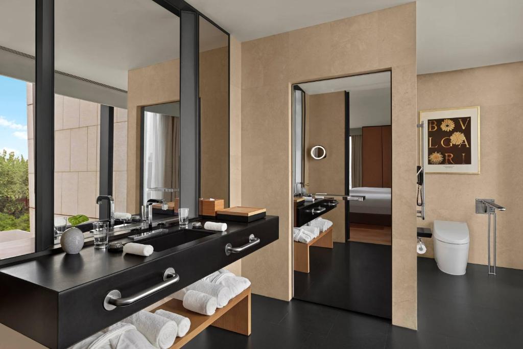 a bathroom with a black sink and a toilet at Bvlgari Hotel Beijing in Beijing