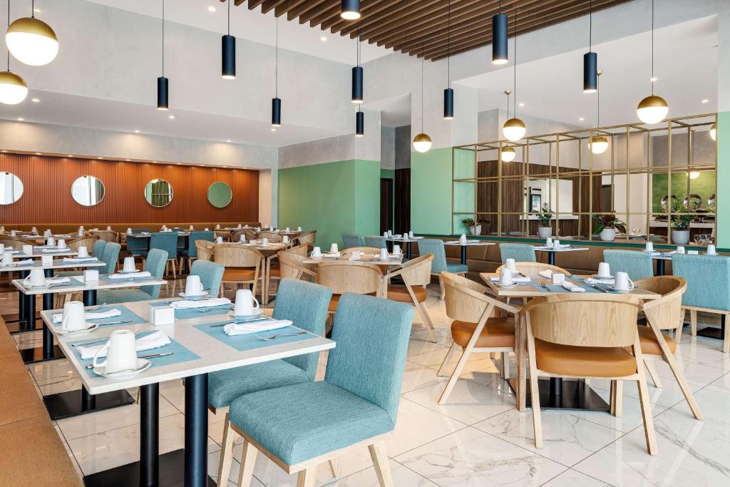 een eetkamer met tafels en stoelen en een restaurant bij Hilton Garden Inn San Jose Airport City Mall in Alajuela