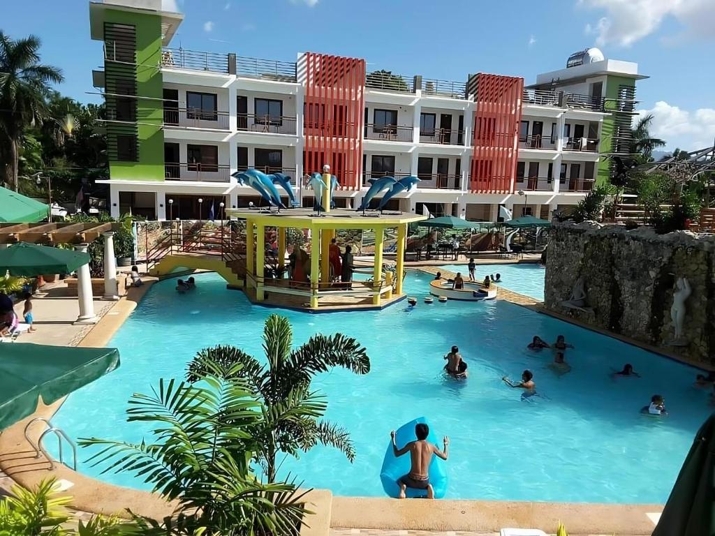 eine Gruppe von Menschen in einem Swimmingpool in einem Resort in der Unterkunft Moalboal Tropics in Moalboal