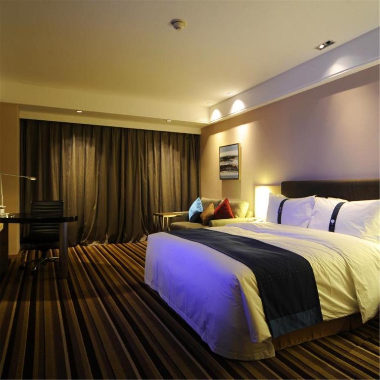 a hotel room with a large bed and a table at Holiday Inn Express Shenyang Golden Corridor by IHG in Shenyang