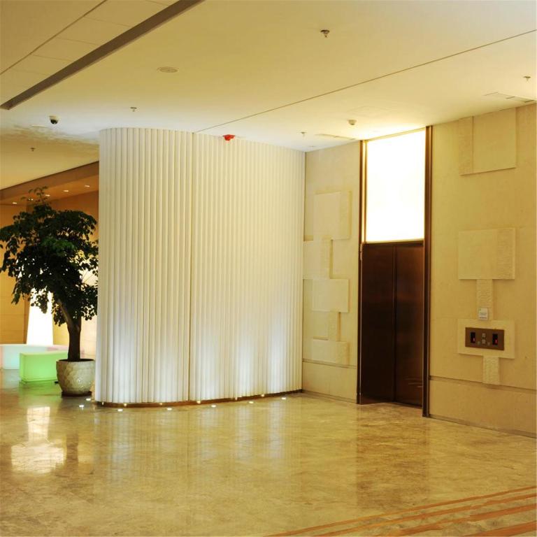a large white wall in a room with a tree at Holiday Inn Express Shenyang Golden Corridor by IHG in Shenyang