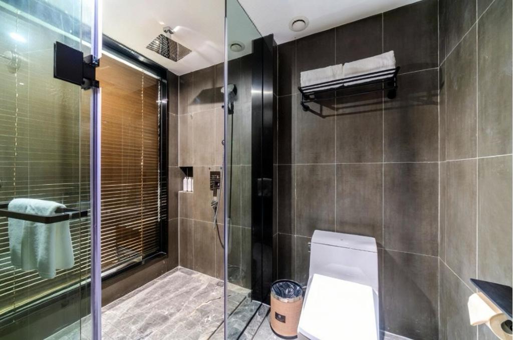 a bathroom with a toilet and a glass shower at LIZ International Hotel Guangzhou Olympic Sports Center International Financial City Branch - Free Shuttle Bus to Canton Fair Complex During Canton Fair Period & Free Breakfast & Free Afternoon Tea & Free Midnight Snack in Guangzhou