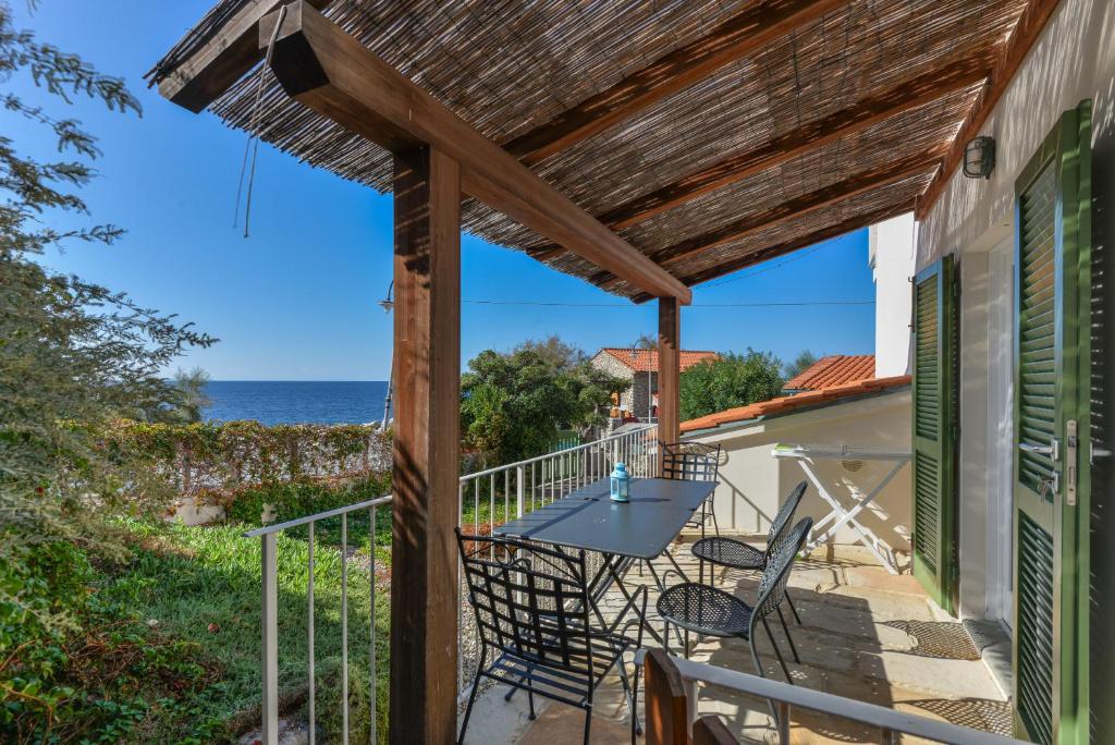 a patio with a table and chairs and the ocean at Il Quartiere apt Giglio in Pomonte