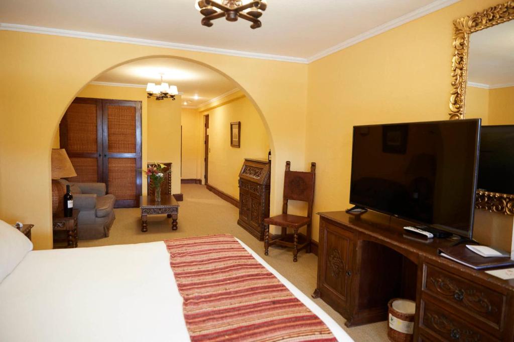 a bedroom with a bed and a flat screen tv at Hotel Santa Cruz Plaza in Santa Cruz
