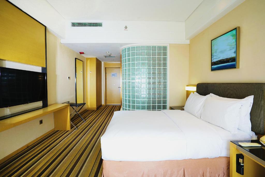 a hotel room with a bed and a flat screen tv at Holiday Inn Express Shenyang Golden Corridor by IHG in Shenyang
