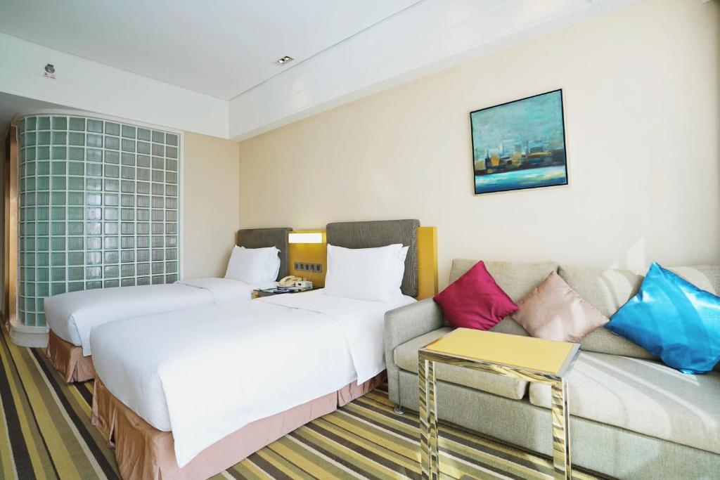 a hotel room with two beds and a couch at Holiday Inn Express Shenyang Golden Corridor by IHG in Shenyang