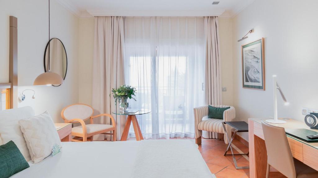 um quarto de hotel com uma cama e uma escrivaninha e um quarto em Bahia del Duque em Adeje