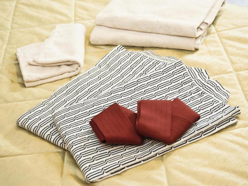 two towels and towels on top of a bed at Shizuoka UI Hotel in Shizuoka