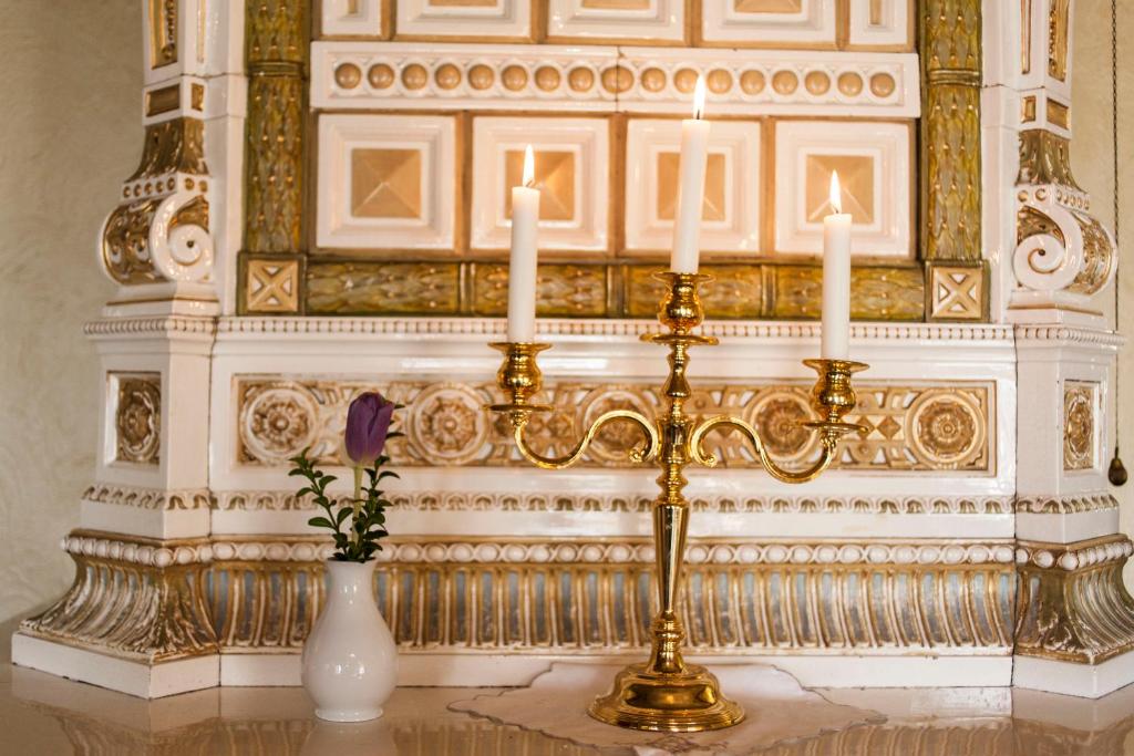 a table with two candles and a vase with a flower at STF Wendelsberg Hotel & Hostel in Mölnlycke