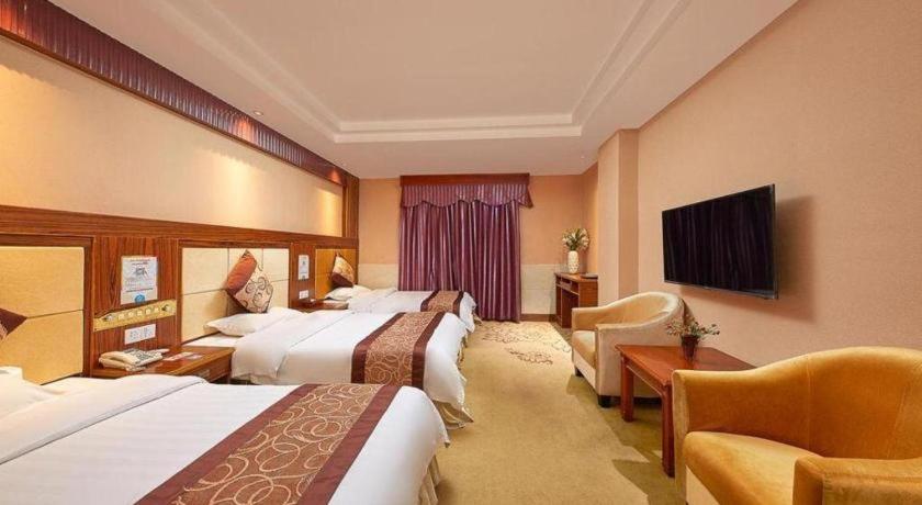 a hotel room with two beds and a television at Airport Liwan Hotel in Huadu