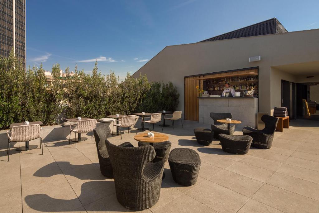 a patio with chairs and tables and a bar at Ohla Eixample in Barcelona