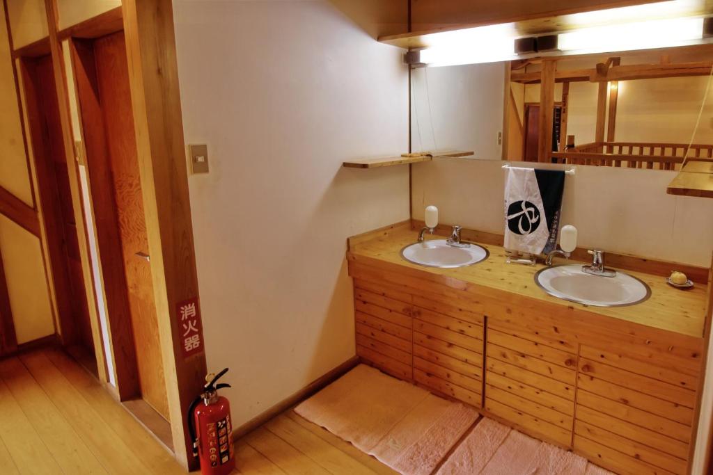 a bathroom with two sinks and a mirror at Guest House Eleven Village Fukiya in Fukiya
