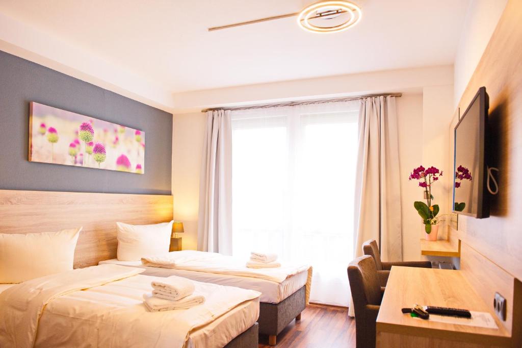 a hotel room with two beds and a window at BlnCty Hotel in Berlin