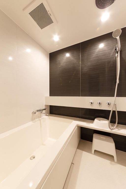 a white bathroom with a tub and a shower at Hotel Citio Shizuoka in Shizuoka