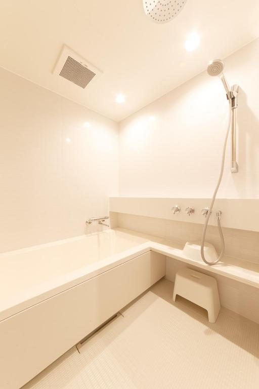 a white bathroom with a shower and a sink at Hotel Citio Shizuoka in Shizuoka