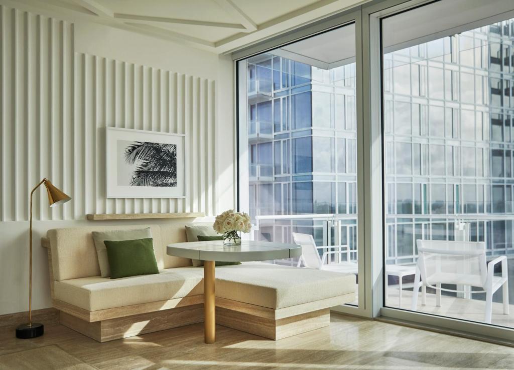 a living room with a table and a chair at Four Seasons Hotel at The Surf Club in Miami Beach