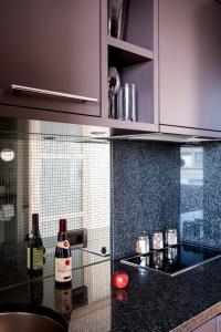 a kitchen with purple cabinets and bottles of wine at The Mandala Berlin, a Member of Design Hotels in Berlin