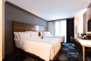 a hotel room with two beds and a desk at Crowne Plaza HY36 Midtown Manhattan by IHG in New York +37 photos