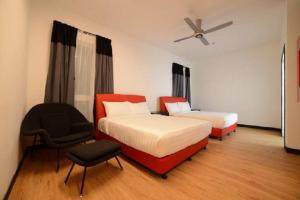 una camera d'albergo con due letti e una sedia di Tune Hotel KLIA-KLIA2, Airport Transit Hotel a Sepang