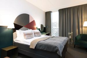 a hotel room with a bed and a chair at Elite Hotel Carolina Tower in Stockholm +26 photos