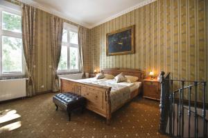 a bedroom with a bed and a chair and windows at Guest house Villa Fritz in Potsdam