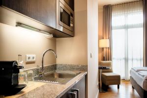 a kitchen with a sink and a bed in a room at Mondrian Suites Berlin am Checkpoint Charlie in Berlin +37 photos