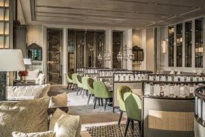 a restaurant with a long bar with green chairs at Four Seasons Hotel Kuala Lumpur in Kuala Lumpur
