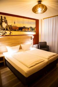 a bedroom with a large bed and a chair at BlnCty Hotel in Berlin