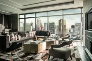 a living room with a couch and a large window at Four Seasons Hotel Kuala Lumpur in Kuala Lumpur