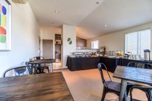 a restaurant with tables and chairs and a kitchen at Parkview On Hagley in Christchurch