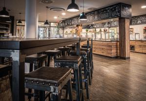 a bar with wooden stools in a restaurant at Spreewelten Hotel in Lübbenau