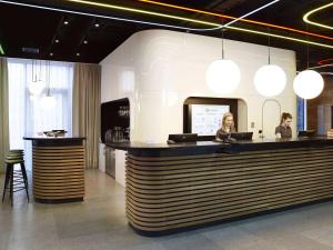 two people sitting at a bar in a restaurant at ibis Styles Warszawa City in Warsaw