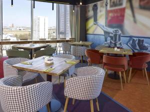 a restaurant with tables and chairs and a large window at ibis Styles Warszawa City in Warsaw