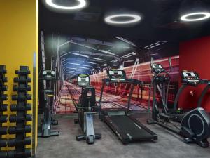 a gym with several tread machines and a painting of a boxing at ibis Styles Warszawa City in Warsaw