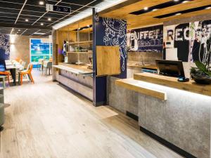 een restaurant met een bar en een eetkamer bij Ibis Budget Sallanches in Sallanches