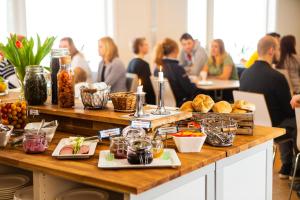 eine Gruppe von Menschen, die an Tischen sitzen und Essen drauf haben in der Unterkunft Lisebergsbyns B&B in Göteborg