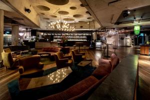 a lobby with couches and chairs and a bar at Ovolo Nishi in Canberra