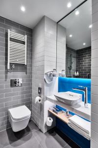 a bathroom with a sink and a toilet and a mirror at Holiday Inn Express - Warsaw - The HUB by IHG in Warsaw