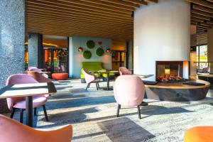 a lobby with pink chairs and a fireplace at Hotel Metropol in Warsaw