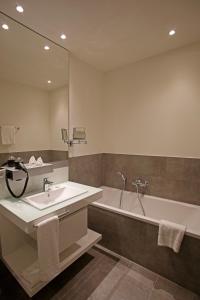 a bathroom with a sink and a bath tub at Grimm´s Berlin Potsdam in Teltow