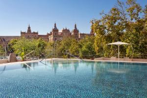 a large swimming pool in front of a large building at Melia Sevilla in Seville