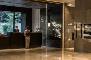 a woman standing at a counter in a lobby at Four Seasons Hotel Kyoto in Kyoto +37 photos