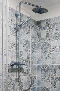 a shower in a bathroom with blue and white tiles at Chalet 5 Laghi / LuxApt / Town Centre in Madonna di Campiglio