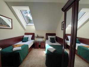 a attic bedroom with two beds and a mirror at Forrest style Pokoje gościnne in Warszawa