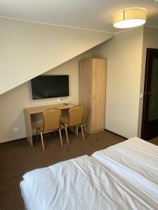 a hotel room with a desk and a television at GRACJA in Warszawa