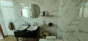 a bathroom with two sinks and a mirror at Penthouse au coeur de Yaoundé Quartier Bastos in Yaoundé +18 photos