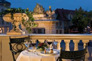 a table with glasses of wine on a balcony at Hotel Am Jägertor in Potsdam