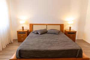 um quarto com uma cama grande com duas mesas de cabeceira em Twin House - Amarante em Amarante mais 8 fotografias